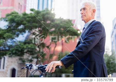 Successful businessman riding bicycle Successful businessman riding bicycle 33570799