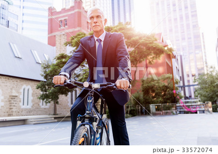 Successful businessman riding bicycle 33572074