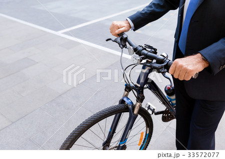 Successful businessman riding bicycle Successful businessman riding bicycle 33572077