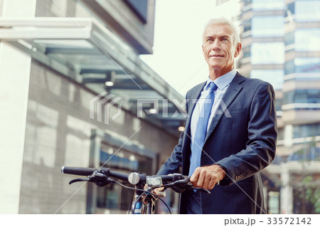 Successful businessman riding bicycle 33572142
