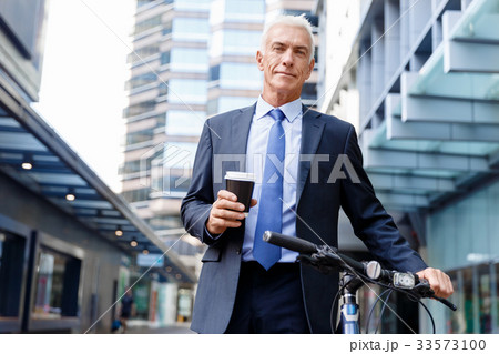 Successful businessman riding bicycle Successful businessman riding bicycle 33573100