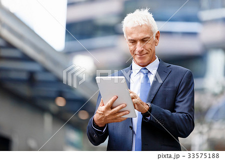 Senior businessman holding touchpad Senior businessman holding touchpad 33575188