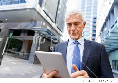 Senior businessman holding touchpad Senior businessman holding touchpad 33575321
