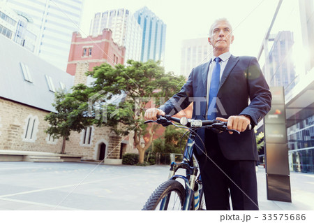 Successful businessman riding bicycle Successful businessman riding bicycle 33575686