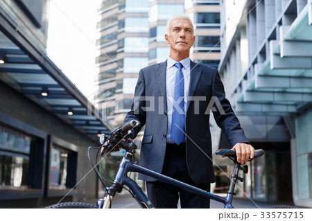Successful businessman riding bicycle Successful businessman riding bicycle 33575715