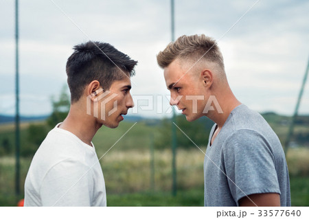 Two boys on playground looking at each other with 33577640