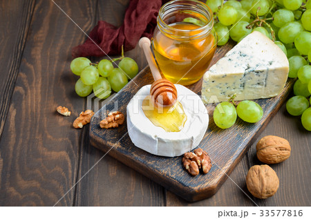 Variety of cheese with grapes, walnuts and honey. Variety of cheese with grapes, walnuts and honey. 33577816