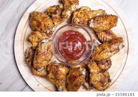 Chicken wings of a barbecue with two sauces. 33580183