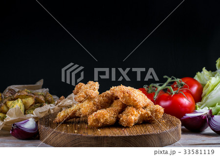 Chicken breast nuggets with vegetables on wooden 33581119