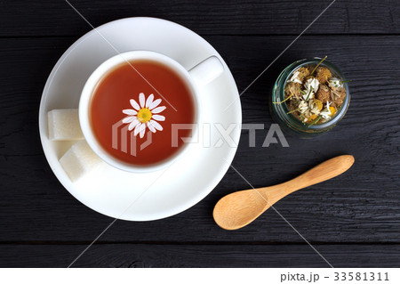 Tea with cubes of sugar, a wooden spoon 33581311
