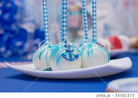 Set of tasty cakes with blue anchor on the plate. 33581373