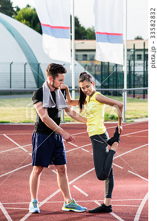 Man and woman on cinder track of sports arena 33582832