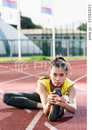 woman athlete stretching on racing track before 33582833