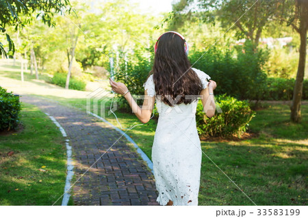 Girl listening music and walking in the park 33583199