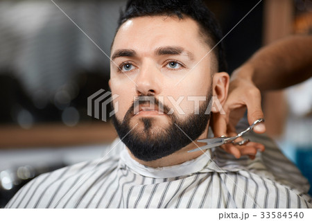 Hairdresser cutting bread with scissors for brunet Hairdresser cutting bread with scissors for brunet 33584540