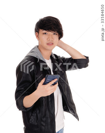 Asian teenager looking at his cellphone. 33584650