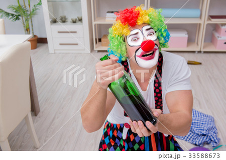 Drunk clown celebrating having a party at home 33588673