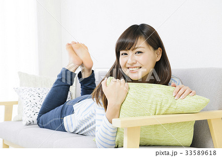 ソファーでリラックスする若い女性 ソファーでリラックスする若い女性 33589618