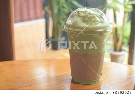 Iced Matcha latte tea on wooden table. Iced Matcha latte tea on wooden table. 33592625