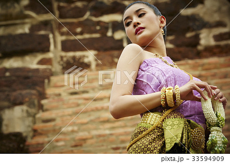 The Thai woman in Thai costume is holding garland on the stair. The Thai woman in Thai costume is holding garland on the stair. 33594909