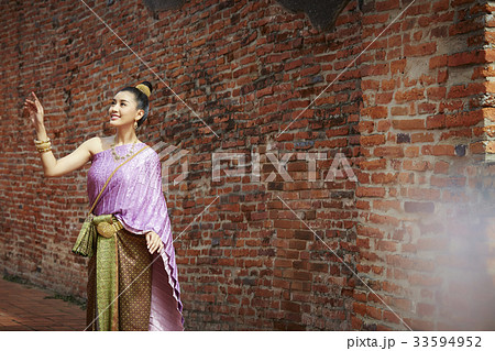 A picture of a Thai woman with a smile posing near a brick wall A picture of a Thai woman with a smile posing near a brick wall 33594952