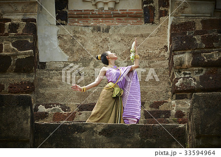 A picture of a Thai woman is dancing in a pagoda 33594964