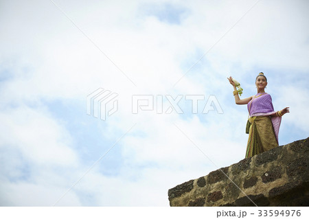 a thai woman is dancing on a top of a temple a thai woman is dancing on a top of a temple 33594976