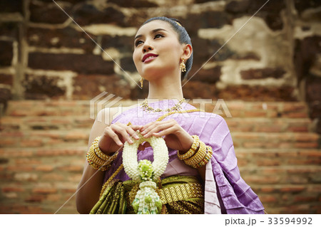 a thai woman is holding a garland and smiling a thai woman is holding a garland and smiling 33594992