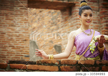 a Thai woman is holding a garland and smiling in old temple a Thai woman is holding a garland and smiling in old temple 33594993