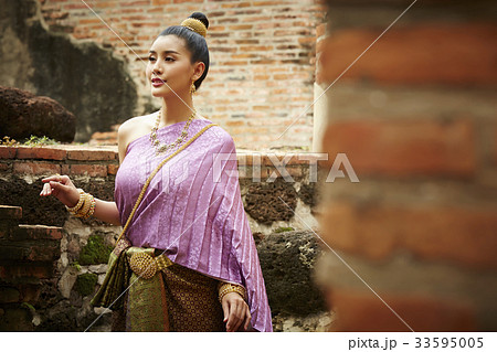 a thai woman is walking and looking at something 33595005