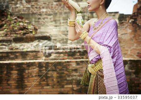 thai woman is holding flower garland in ancient temple 33595037