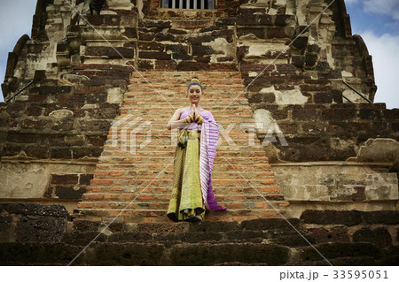 a thai woman is welcoming with hands together in historical park 33595051