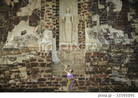thai woman is posing in front of buddha statue at ayutthaya thai woman is posing in front of buddha statue at ayutthaya 33595095