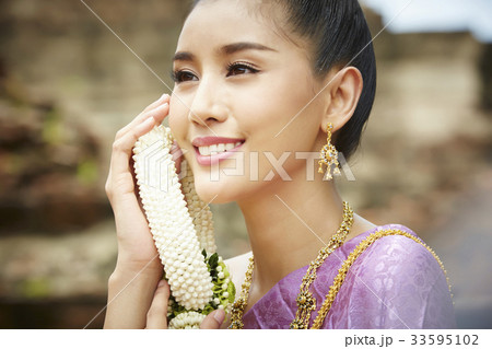 photo of thai woman holding ornament and smiling 33595102