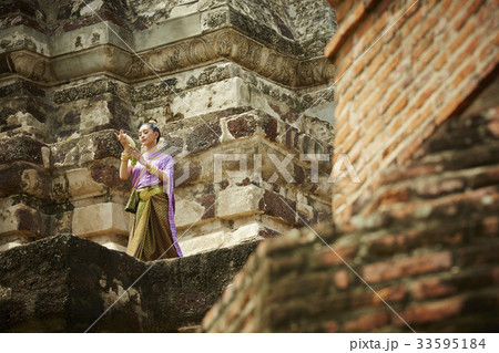 The picture of a Thai woman standing in the ground of pagoda The picture of a Thai woman standing in the ground of pagoda 33595184