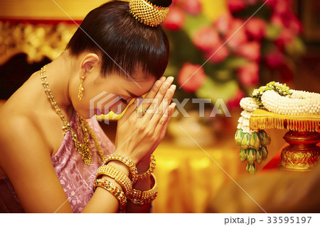 The portrait of a Thai girl kneeling, clasping hands and praying The portrait of a Thai girl kneeling, clasping hands and praying 33595197