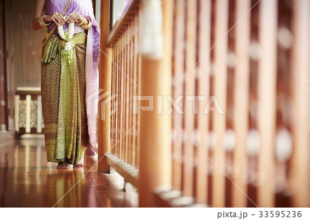 A Thai woman is holding the Thai ornament while standing on the balcony. A Thai woman is holding the Thai ornament while standing on the balcony. 33595236