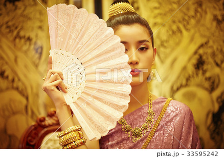 A photo of Thai woman hiding her face by using the fan. 33595242