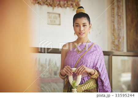 A portrait of Thai woman standing beside the ancient wall. 33595244