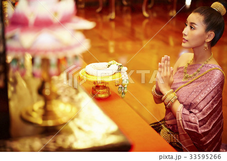A beautiful Thai woman is staring at the altar while praying. A beautiful Thai woman is staring at the altar while praying. 33595266