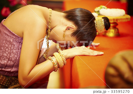 A photo of Thai woman genuflecting while praying seriously. 33595270