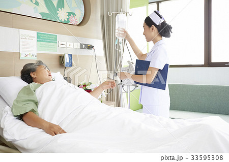 a picture of a nurse talking and taking care of her patient 33595308