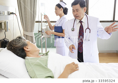 Doctor is talking to elderly patient on bed in hospital Doctor is talking to elderly patient on bed in hospital 33595324
