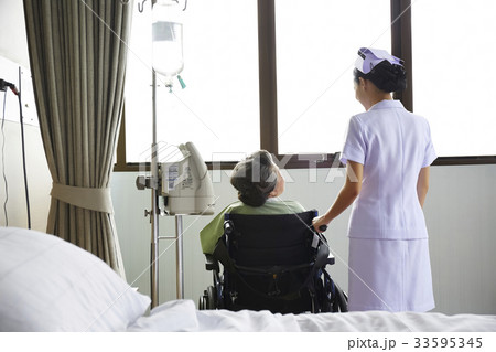 A nurse and a patient are talking each other near a window A nurse and a patient are talking each other near a window 33595345