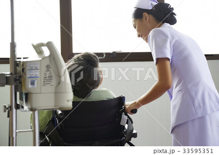 A nurse is taking care of an old patient in a hospital 33595351