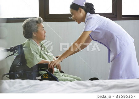 A picture of a nurse talking friendly to an old patient A picture of a nurse talking friendly to an old patient 33595357