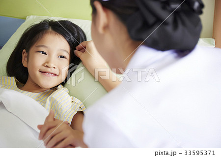 A kid patient is looking at a nurse and smiling A kid patient is looking at a nurse and smiling 33595371