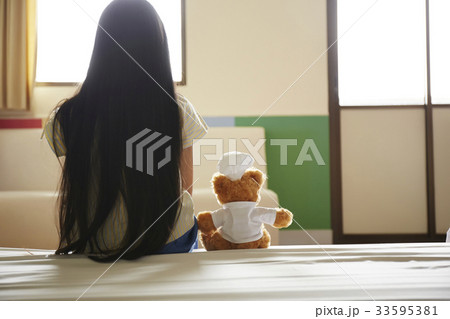 Sad girl is waiting for parents alone together with teddy bear 33595381