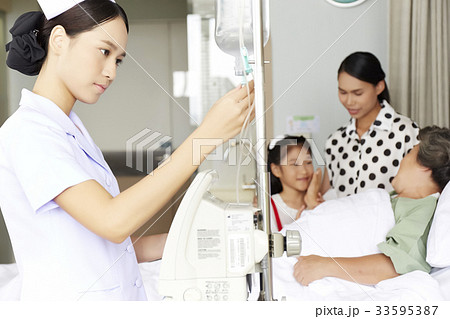 a nurse is checking medical equipment in elderly woman's room a nurse is checking medical equipment in elderly woman's room 33595387