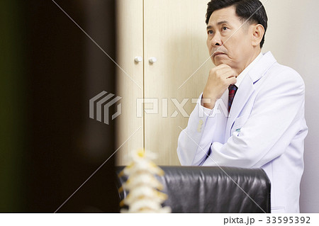 a doctor is standing and thinking in office a doctor is standing and thinking in office 33595392